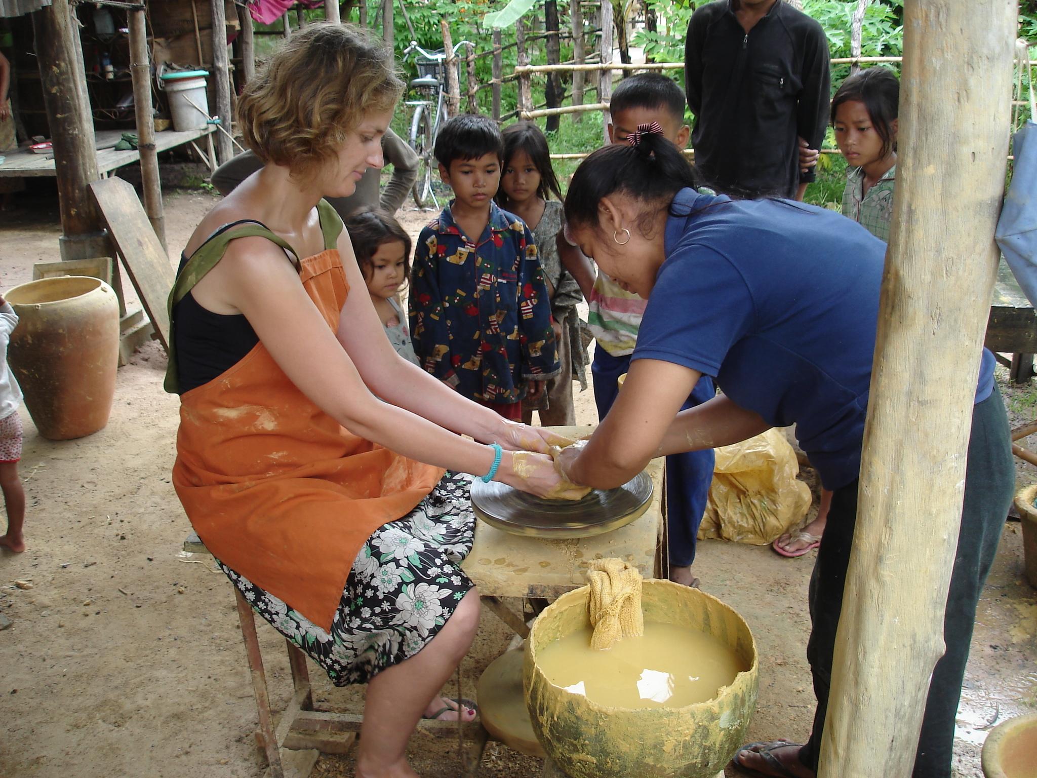 Female Projects Abroad Community Volunteer on a Khmer Project is being taught how to mould clay during a Cultural immersion project in Cambodia. Female Culture and Community Volunteer is taught by local pottery makers how to mould clay during her volunteering placement in Cambodia.